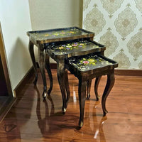 Blossom Breeze wooden nesting table set with hand-painted floral designs on a black surface, crafted from Kikar wood and MDF for a vintage home accent.