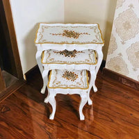 Fern Harmony wooden nesting table set with elegant hand-painted gold floral patterns on a white base, crafted from Kikar wood and MDF for a luxurious home accent.