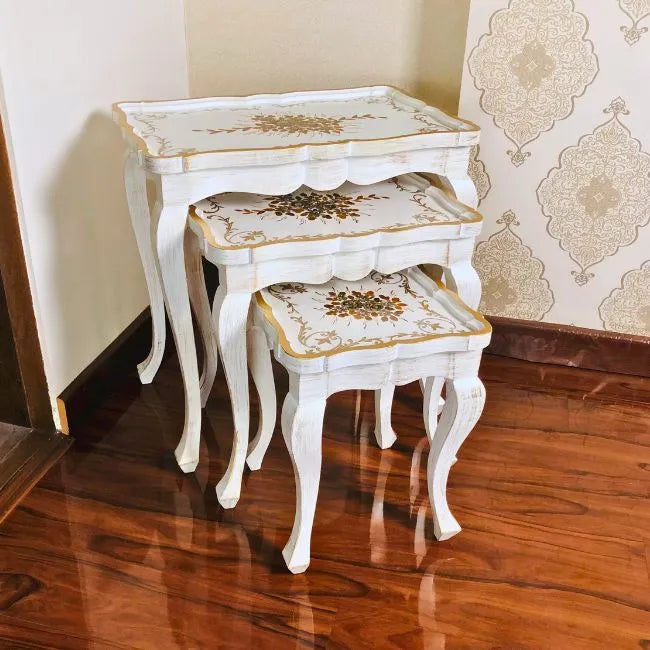 Side view of Fern Harmony wooden nesting tables showcasing intricate gold floral detailing and graceful curved legs
