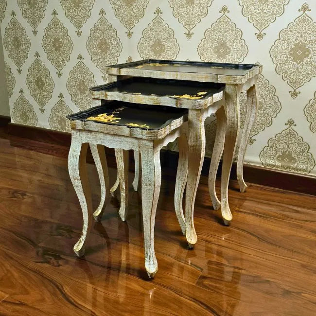 Space-saving Golden Fern nesting tables stacked together, featuring an elegant black top with gold floral artwork