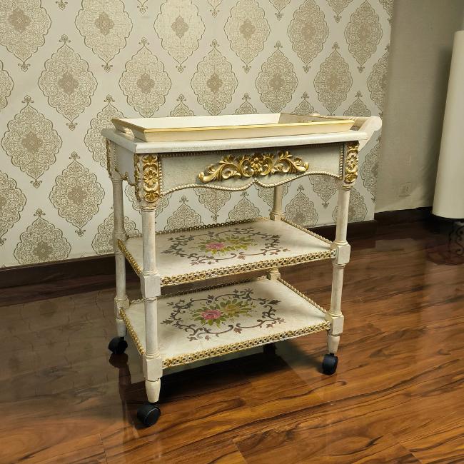 Front view of hand-painted wooden serving trolley with floral designs and durable construction.