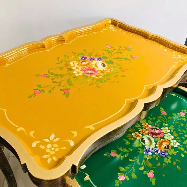 Space-saving Harmony Hues nesting tables stacked together, featuring multicolor hand-painted tops with a rich wooden finish