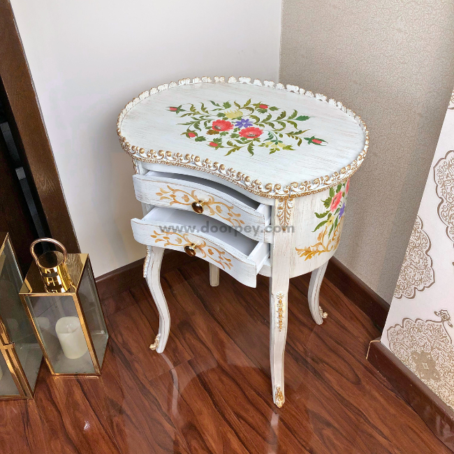 White wooden side table with drawers open. The table is beautifully decorated with colorful hand painted patterns