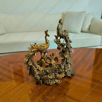 Decorative gold peacock sculpture on a wooden table with a white sofa in the background