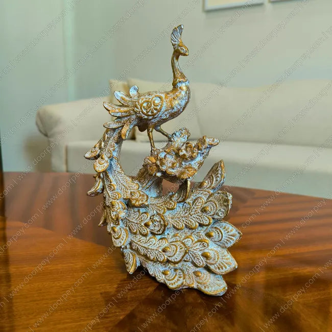 Decorative peacock sculpture on a wooden surface with a blurred background