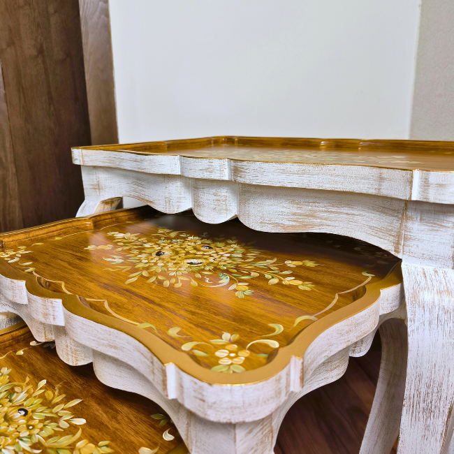 Rustic Ramble wooden nesting tables placed in a classic interior, adding warmth and elegance with their gold floral artistry.