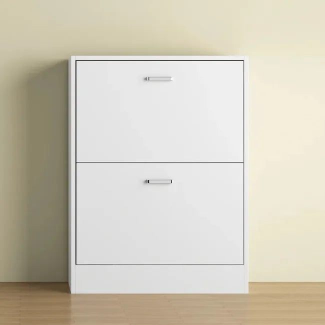 White shoe organizer with two doors on a beige wall and wooden floor.