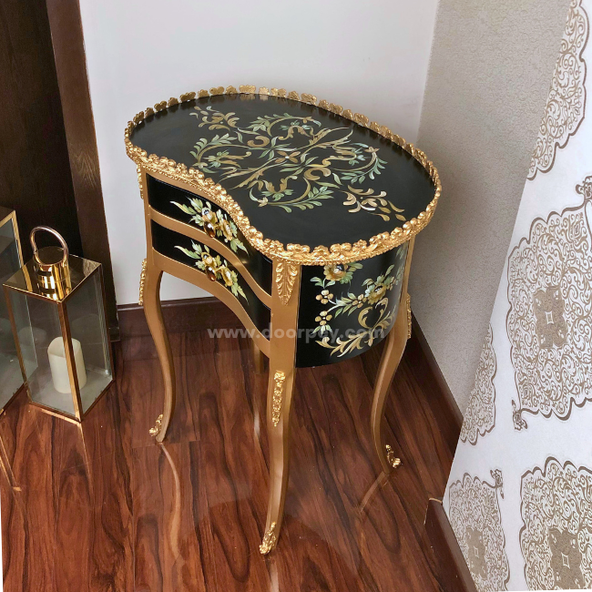 Side profile of a black and golden wooden side table with hand painted patterns.