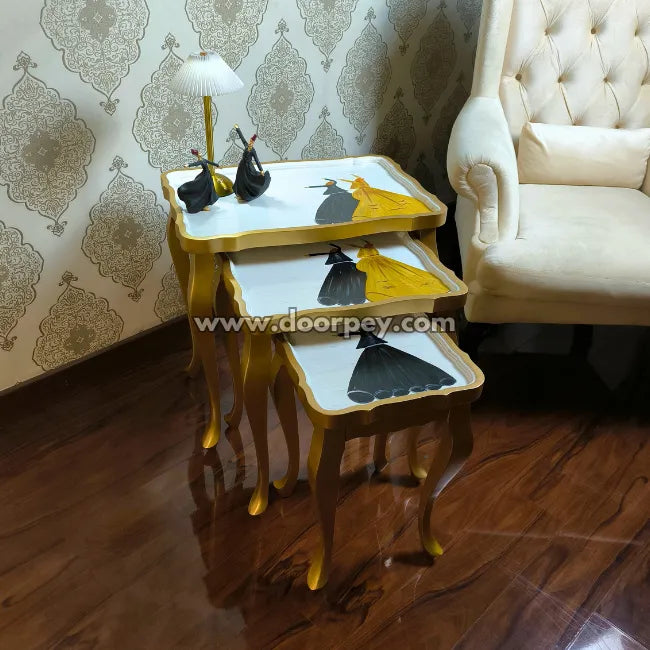Wooden nest tables with decorative items against a patterned wall.