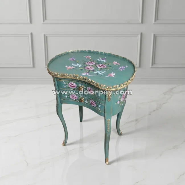 Decorative kidney shaped table with floral patterns on a white floor and gray paneled wall.
