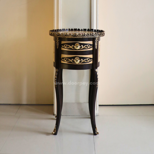 A wooden side table placed between two doors on a tiled floor.