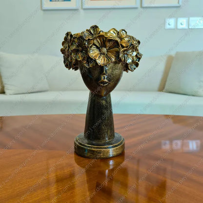 Decorative home decor sculpture of a head with floral crown on a wooden table