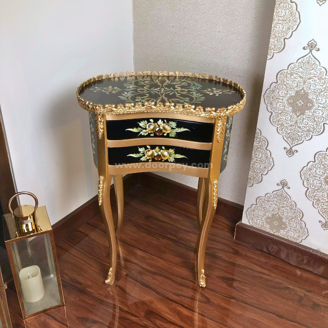 Front view of a decorative wooden side table with hand painted patterns on a wooden floor.