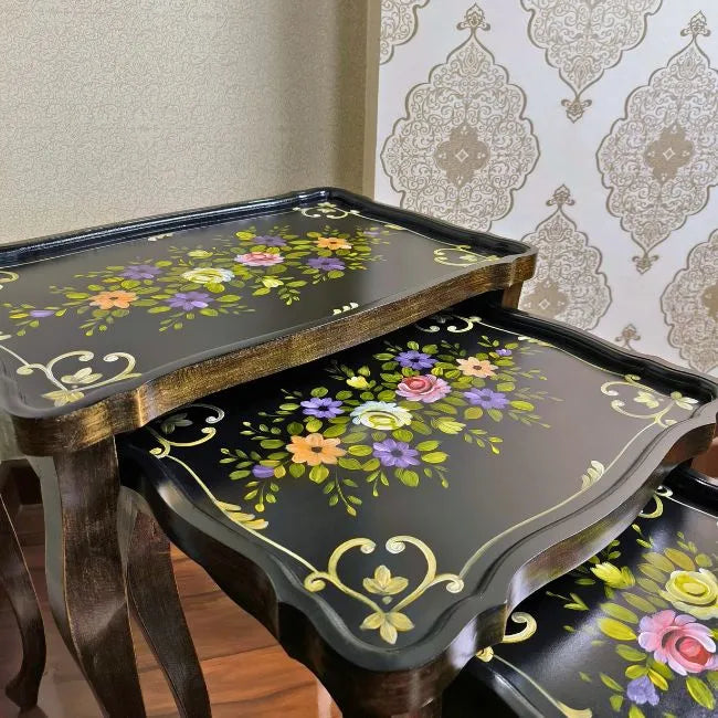 Space-saving Blossom Breeze nesting tables stacked together, featuring a luxurious hand-painted floral pattern on a classic black wood finish