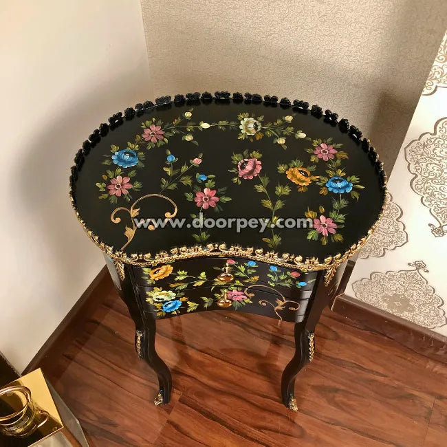 Decorative side table with floral patterns on a wooden floor.