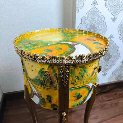 Decorative hand painted wooden table with artistic design and gold accents on a wooden floor.