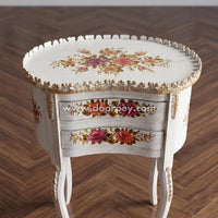 Wooden end table with floral patterns on a wooden floor