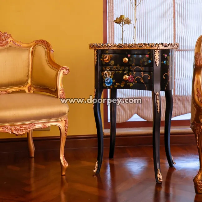Decorative wooden table with intricate designs in a room with gold chairs.