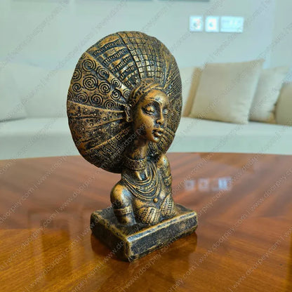 Bronze statue of a woman with intricate headdress on a wooden table for home decor