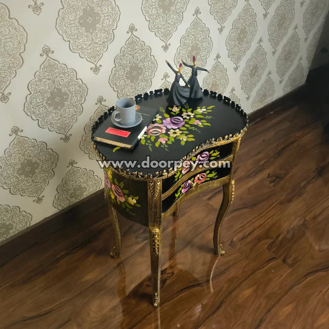 Decorative wooden bedside table with floral patterns and a couple figurine against a patterned wall.