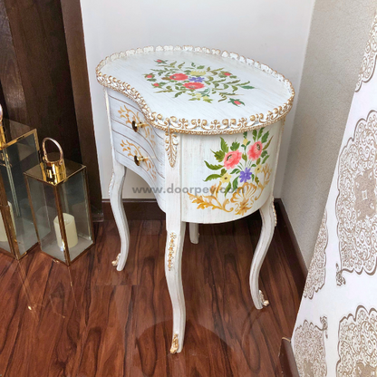 Side profile of a white wooden bedside table on a wooden floor.