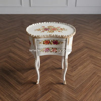 Wooden side table with floral patterns on a wooden floor