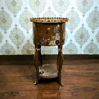 Decorative wooden side table with gold accents against a patterned wallpaper background