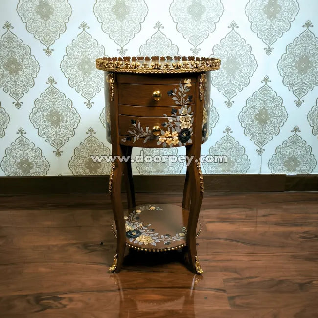 Decorative wooden side table with gold accents against a patterned wallpaper background