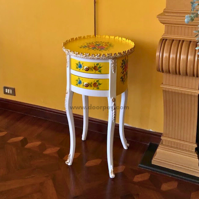 Side profile of a white and yellow wooden side table with colorful painted patterns and gold trims