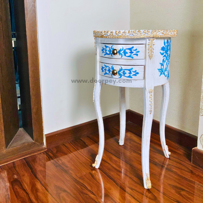 Side profile of a wooden side table with gold trims on a wooden floor.