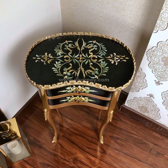 Top view of a black and golden wooden bedside table on a wooden floor.