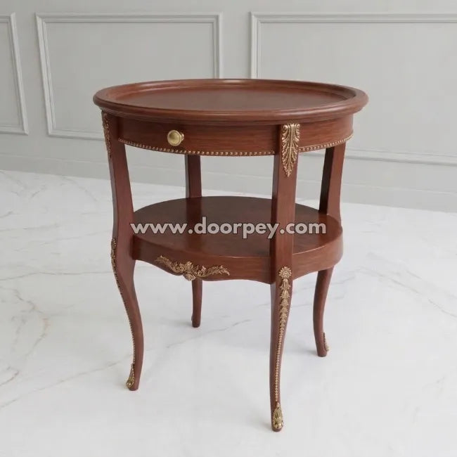 Wooden side table with gold accents on a white marble floor.