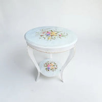 White hand painted round wooden side table featuring floral artwork and elegant curved legs crafted from kikar wood